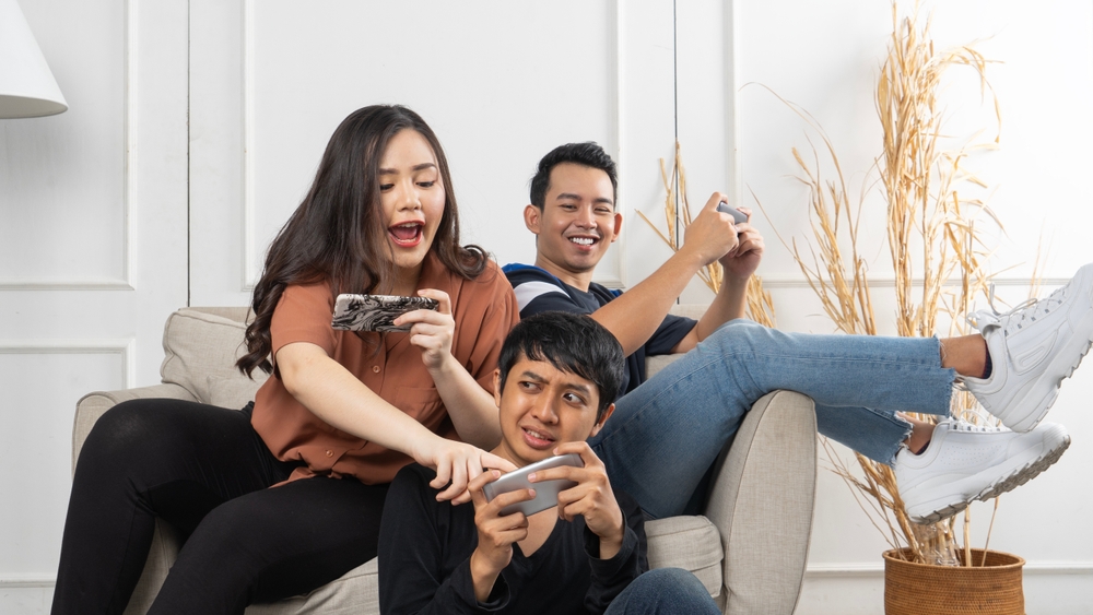 Group,Of,Young,Asian,People,Sitting,And,Addicted,To,Playing